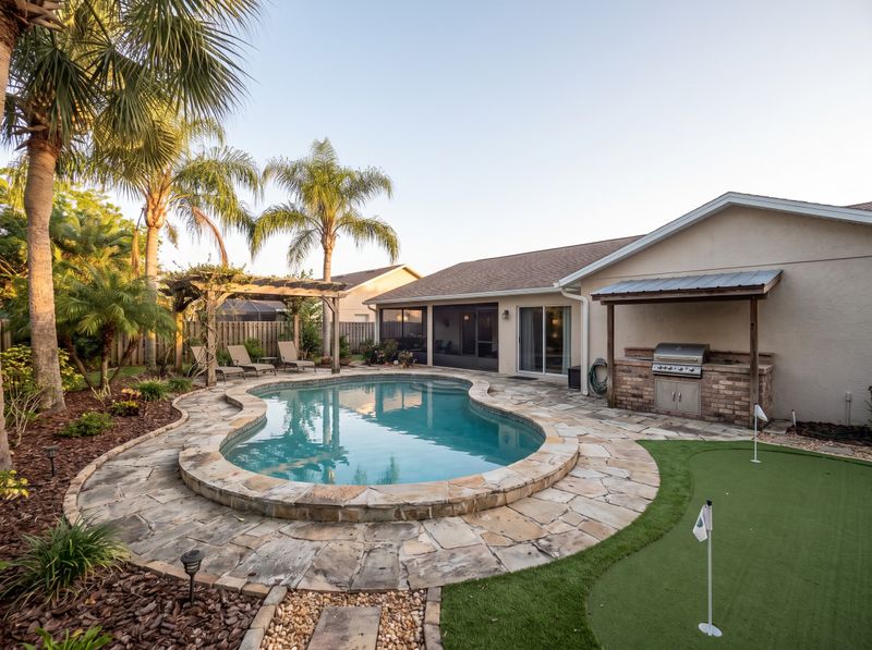 Curved Pool Beside Putting Green and Palms