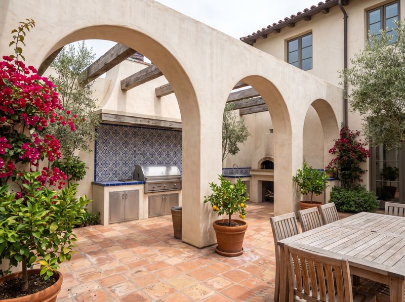 Courtyard Outdoor Kitchen Beneath Stucco Arches
