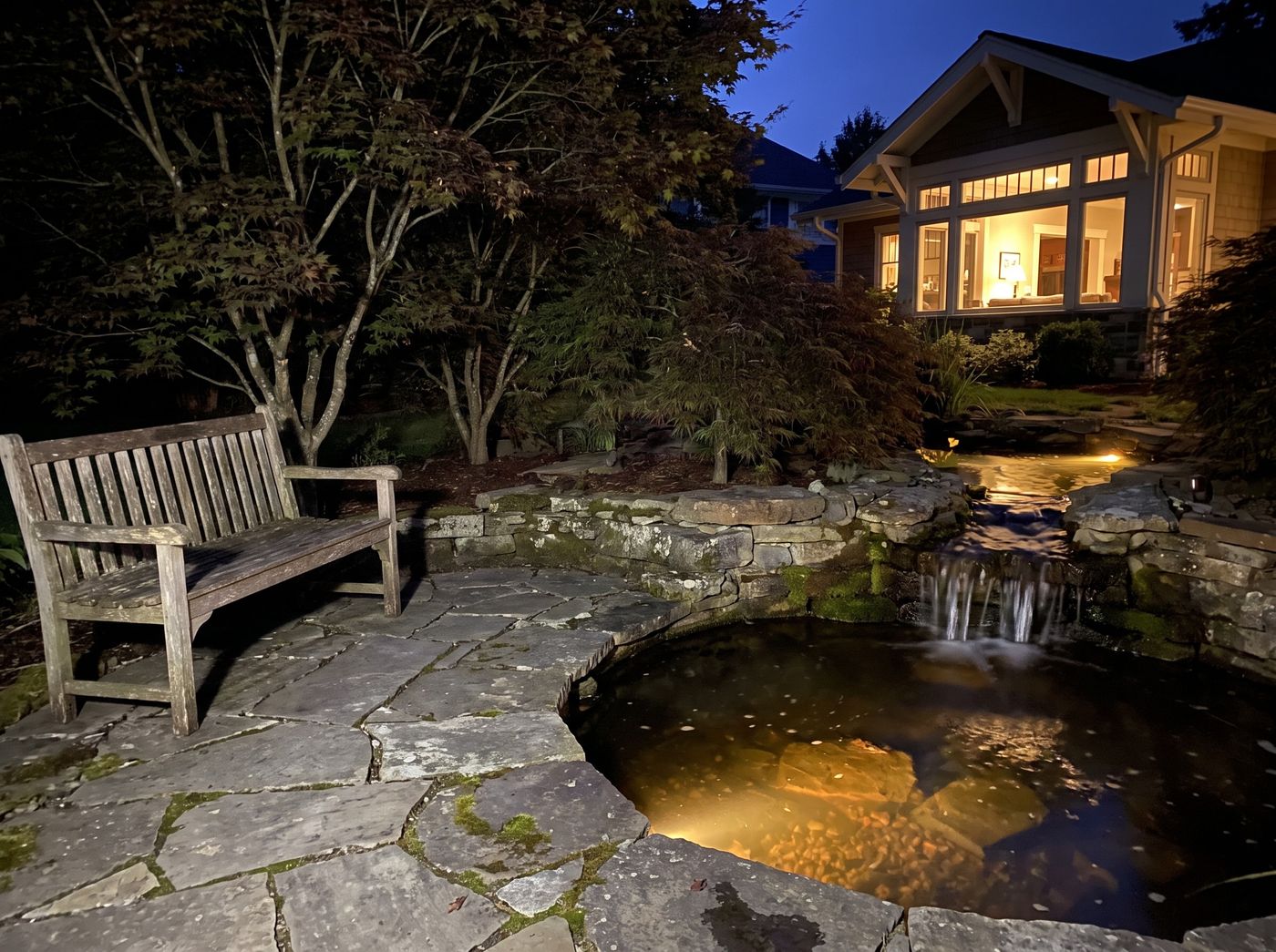 Lit Stone Pond with Cascading Waterfall