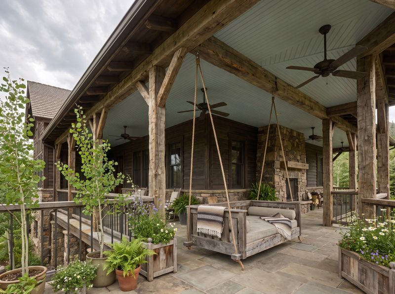 Wraparound Porch Featuring a Rustic Swing Bed